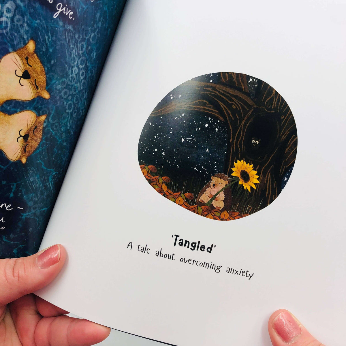 Book titled 'Tangled: A tale about overcoming anxiety' held open by a hand.