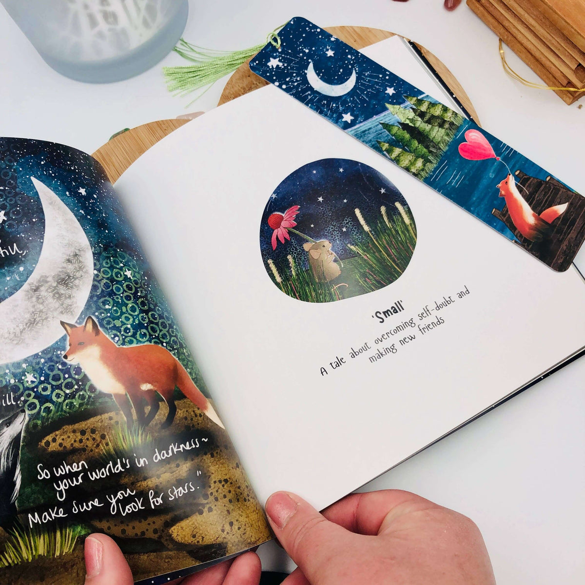 Children's book with fox illustrations and a colorful bookmark on a white surface.