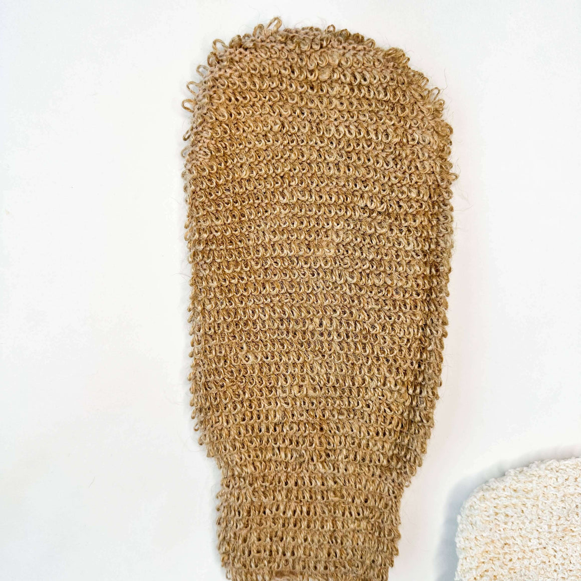 Brown loofah glove on a white background