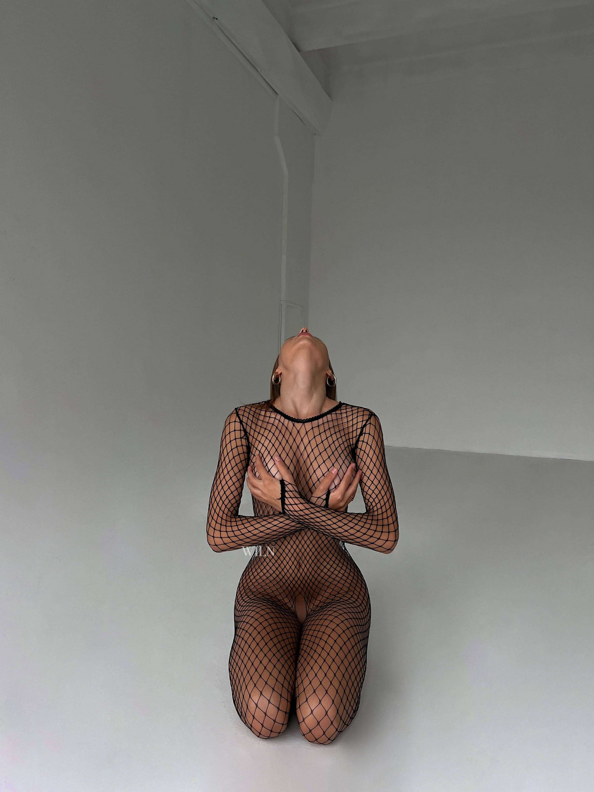 Model showcasing the PREY Fishnet Bodysuit, highlighting its flattering design and flexible fit.