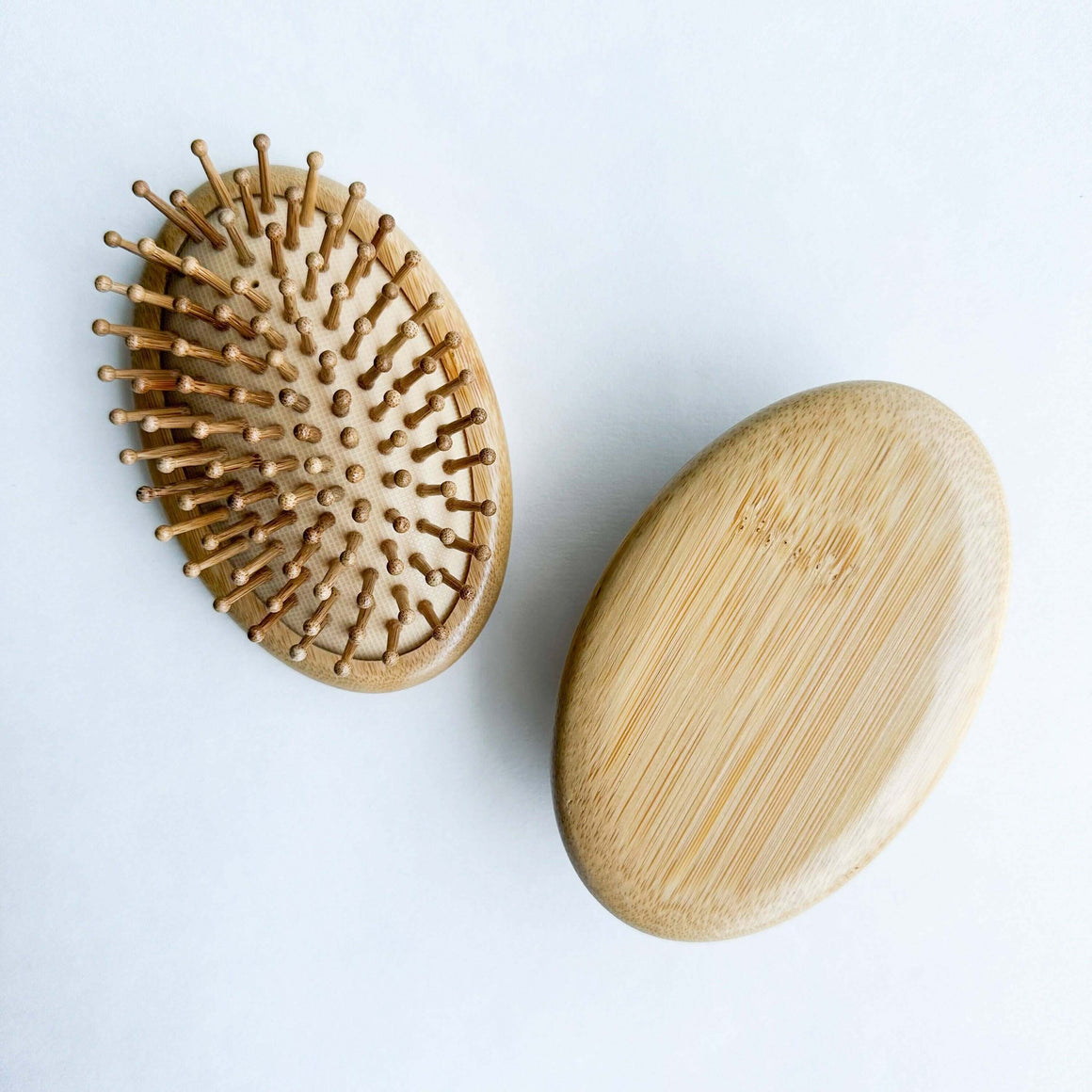 Wooden hairbrush and wooden soap on a light gray background