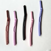 Five eyebrow razors of different colors on a white background