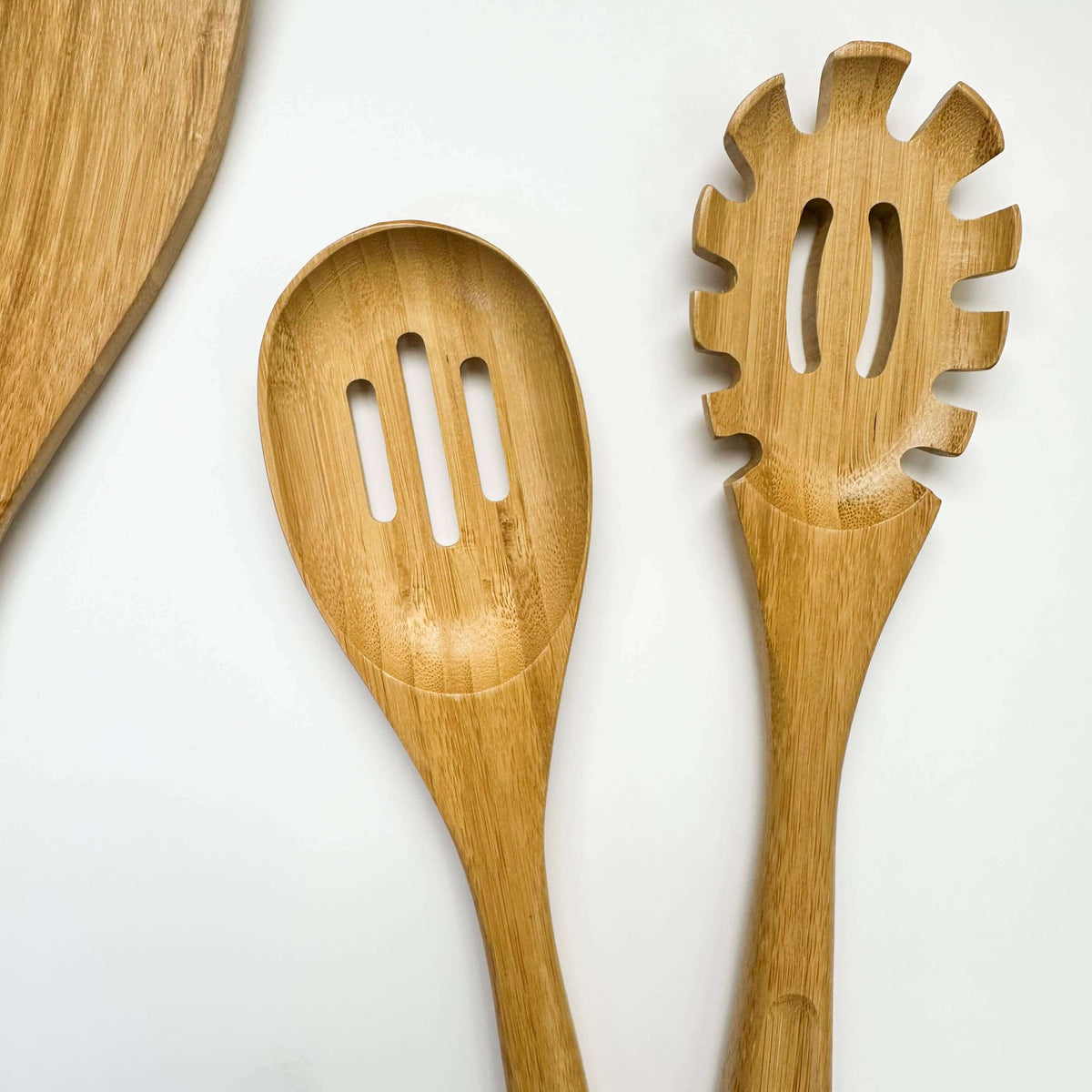 Three wooden kitchen utensils on a white background