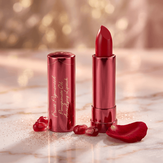 Red lipstick with packaging on a marble surface with rose petals