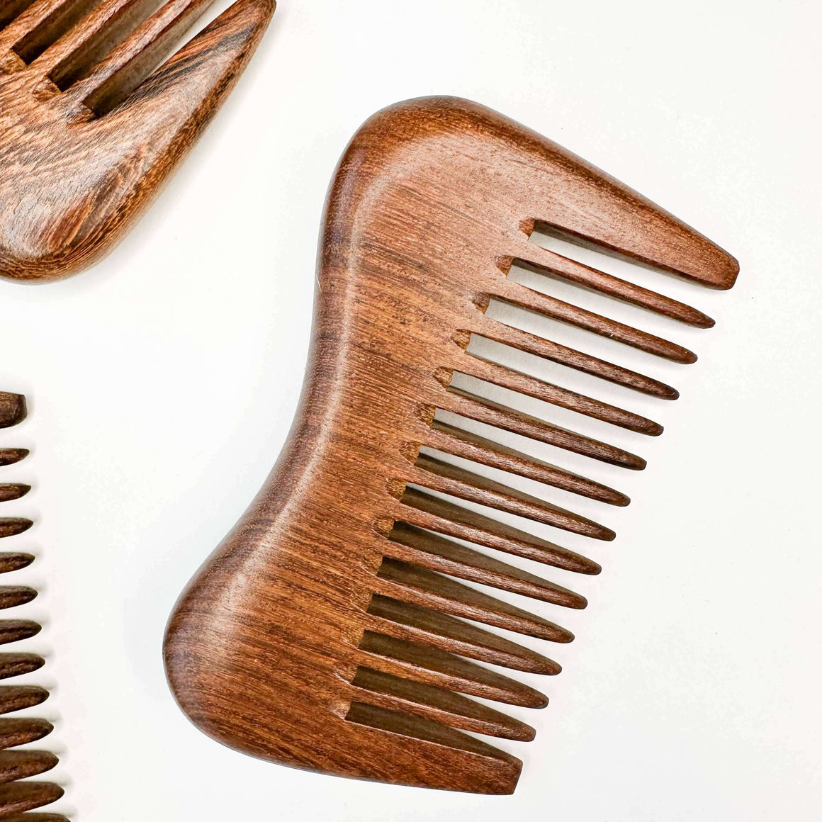 Two wooden combs on a white background