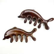 Two wooden dolphin-shaped combs on a white background