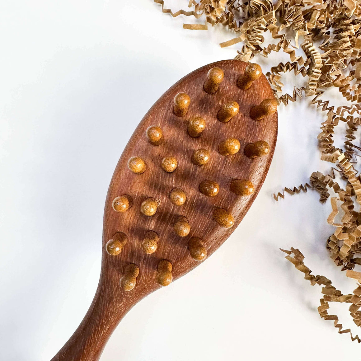 Wooden brush with raised spheres on a white background