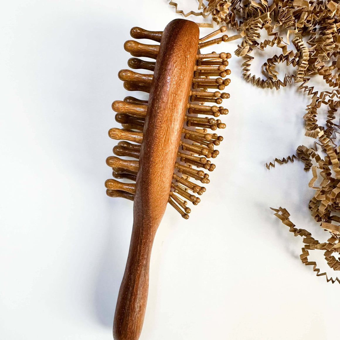 Wooden hairbrush with natural bristles on a light background