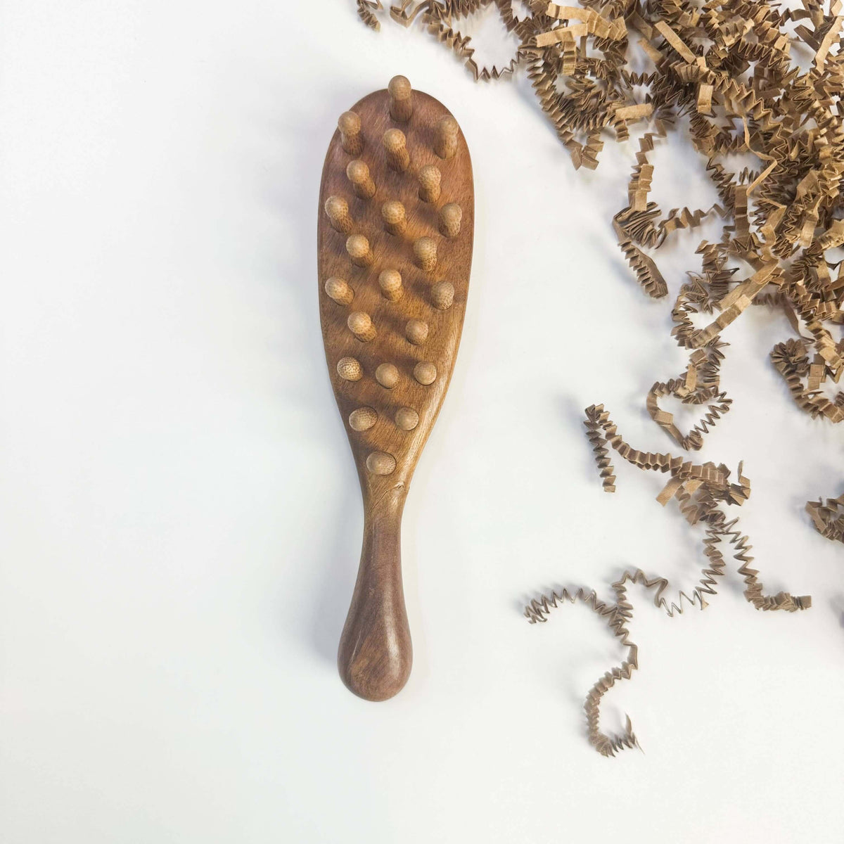 Wooden brush with bristle-like ends on a white background
