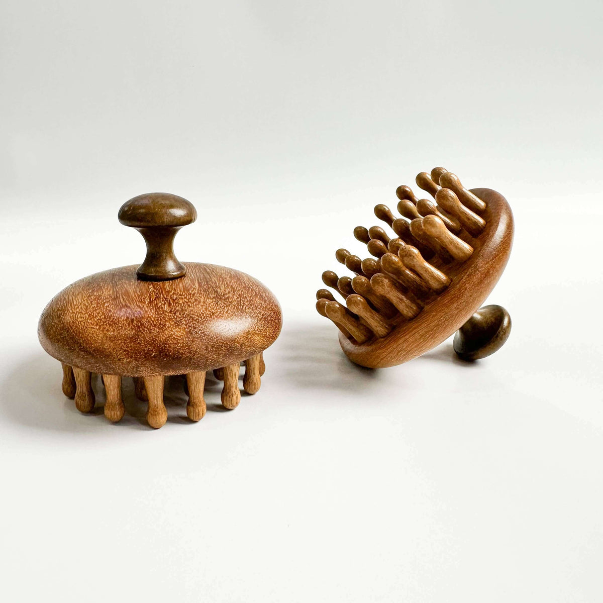 Two wooden massage tools on a white background