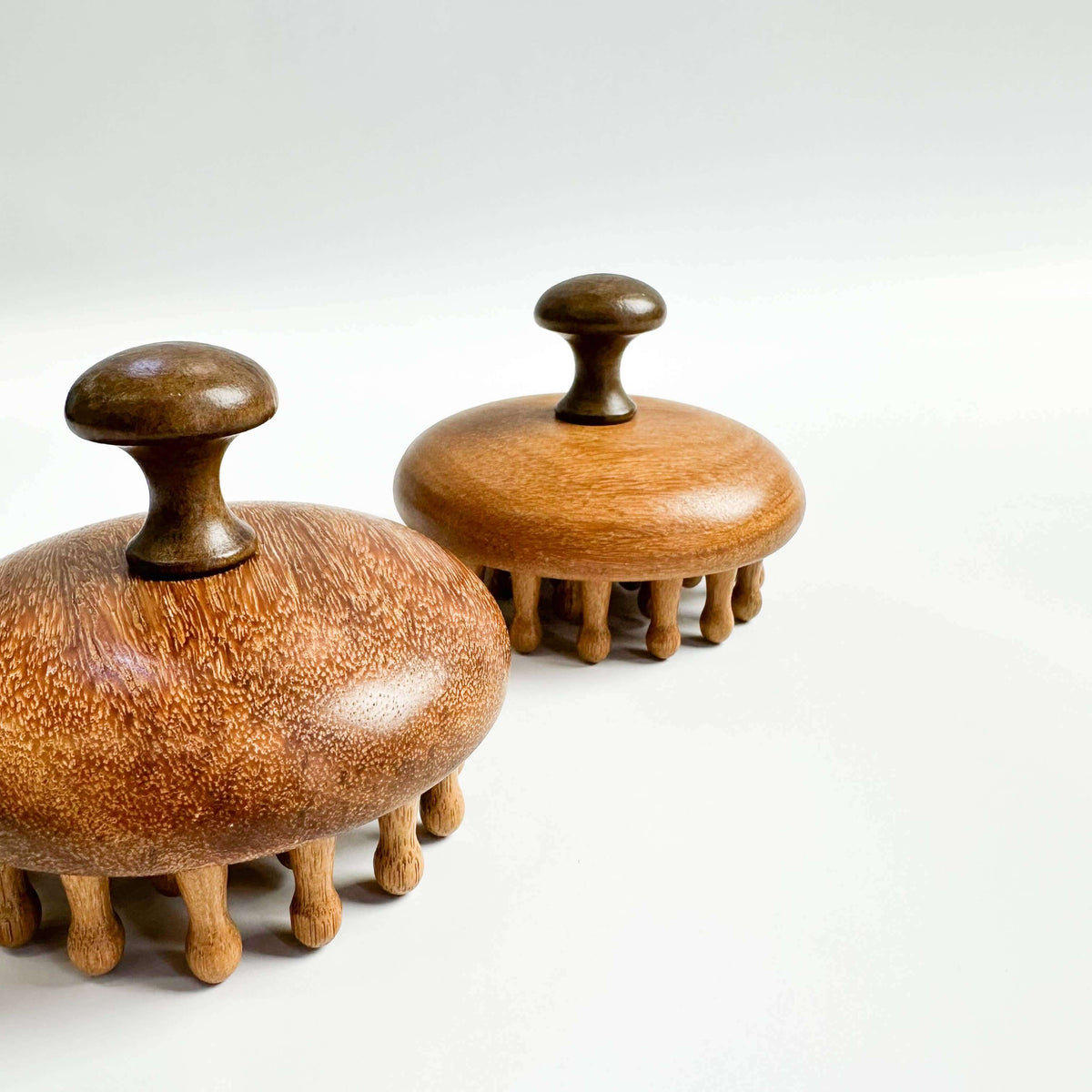 Two wooden massage tools on a white background