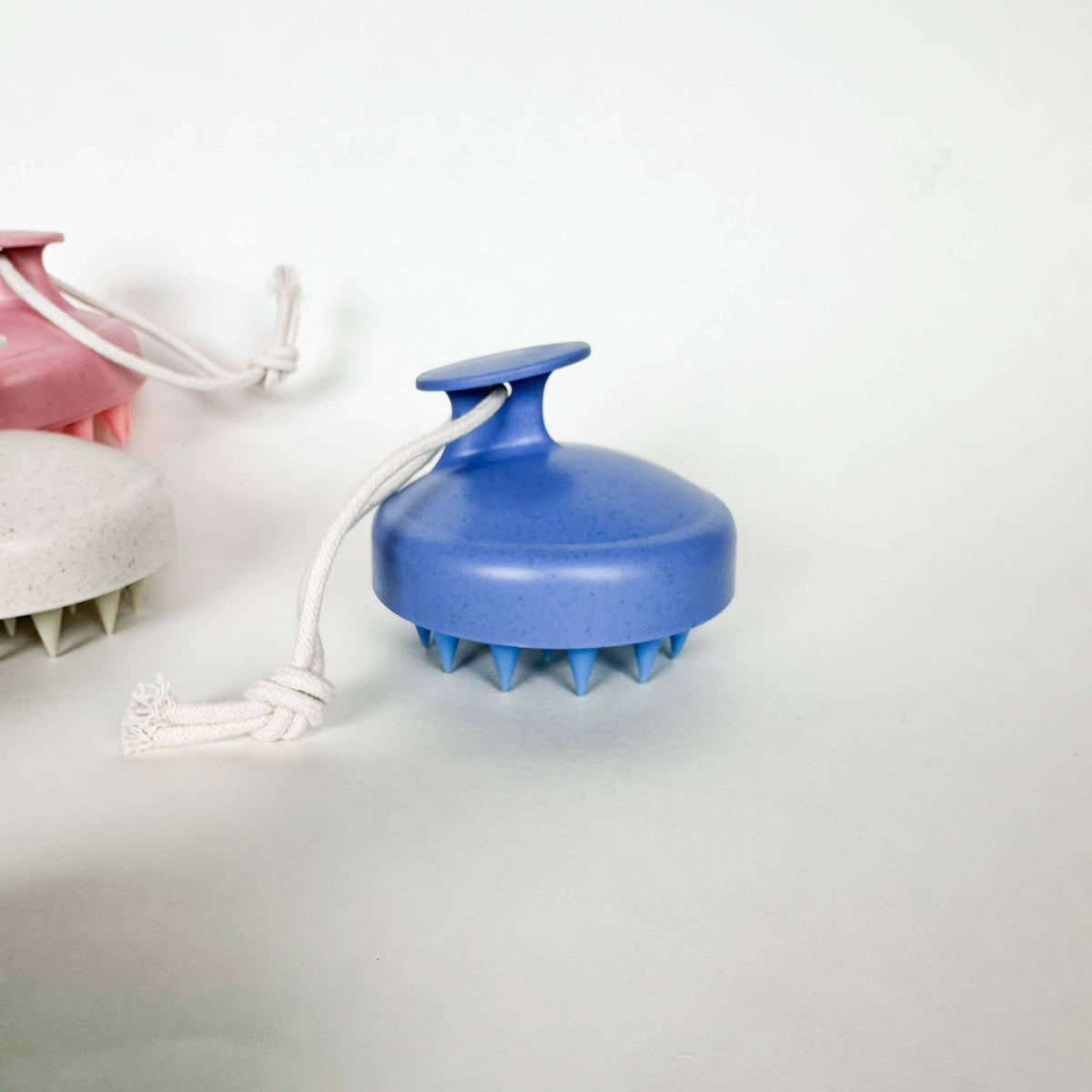 Blue handheld massager with a white cord on a light gray background