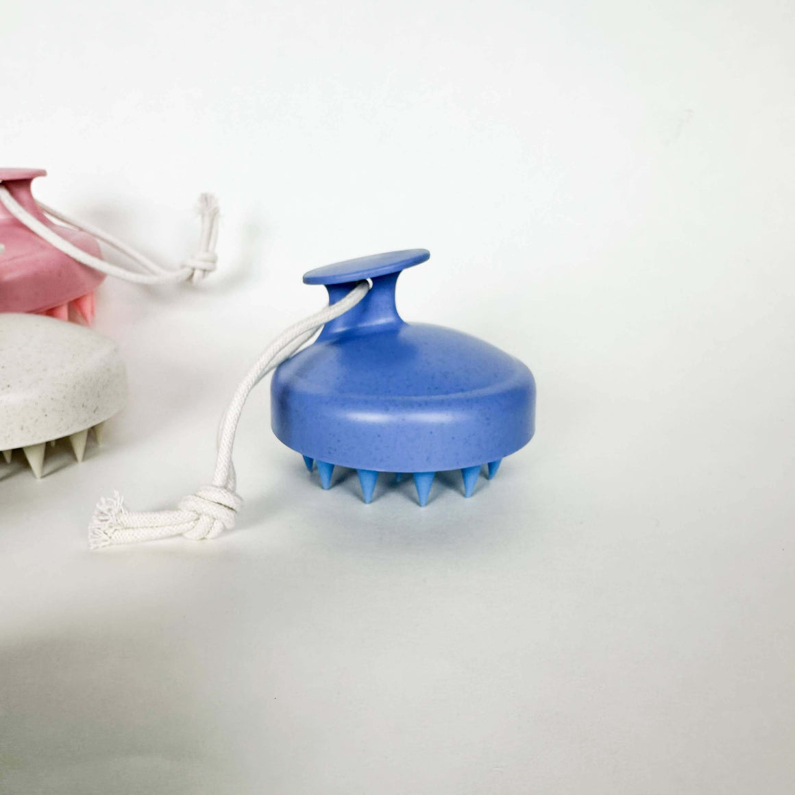 Blue handheld massager with a white cord on a light gray background