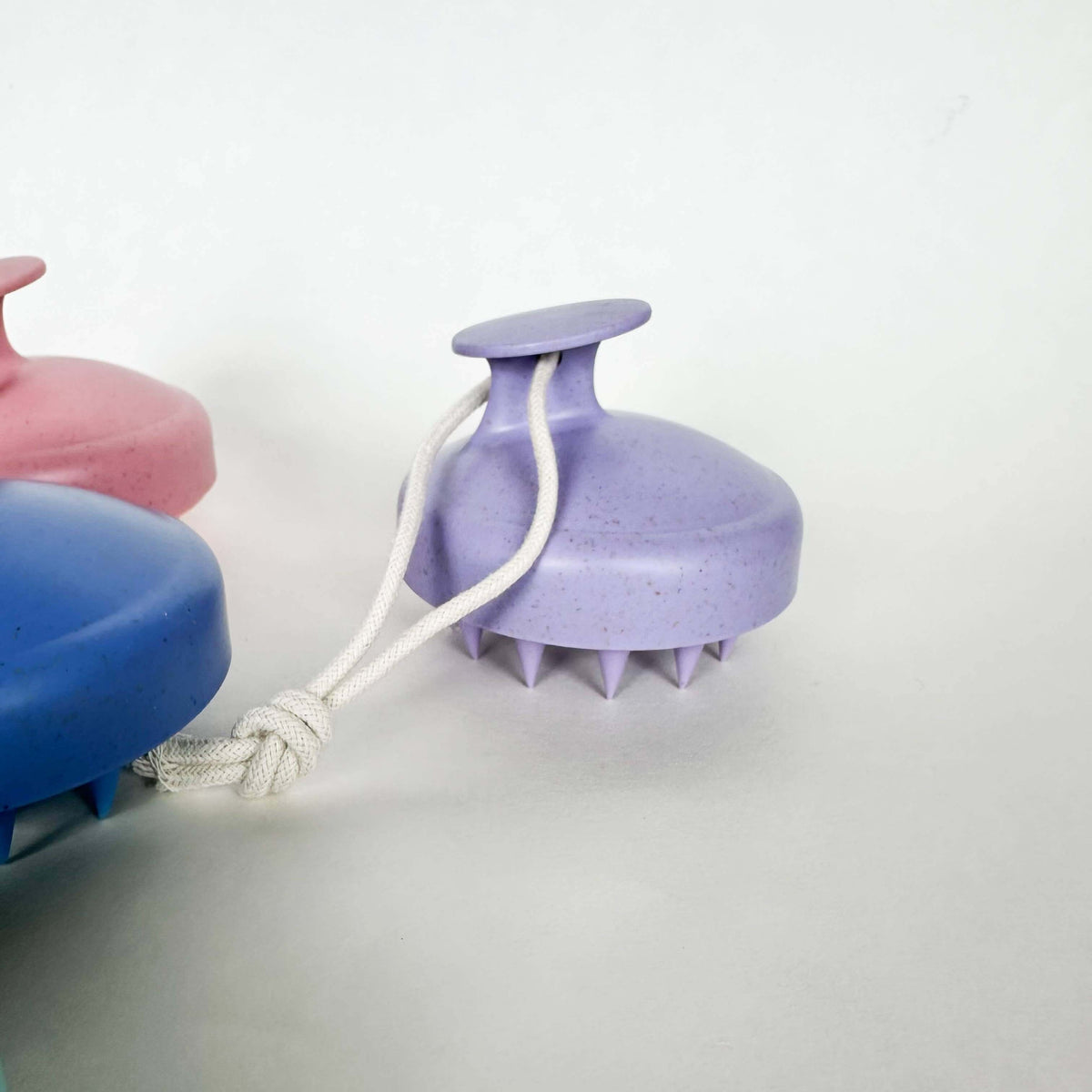 Purple scrubber with a white rope on a light gray background
