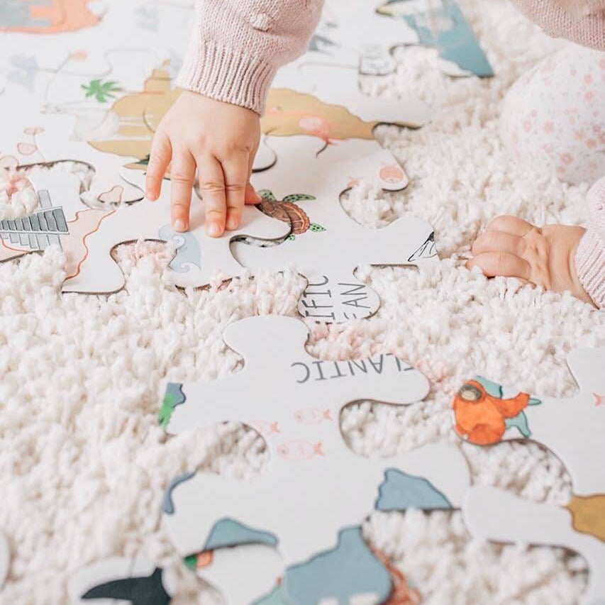 Children playing with a puzzle on a soft surface