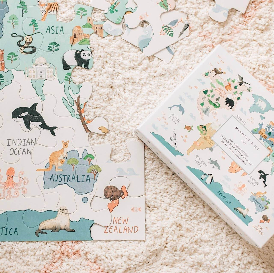 Children's puzzle with animal illustrations on a map of the world, partially completed, on a soft surface.