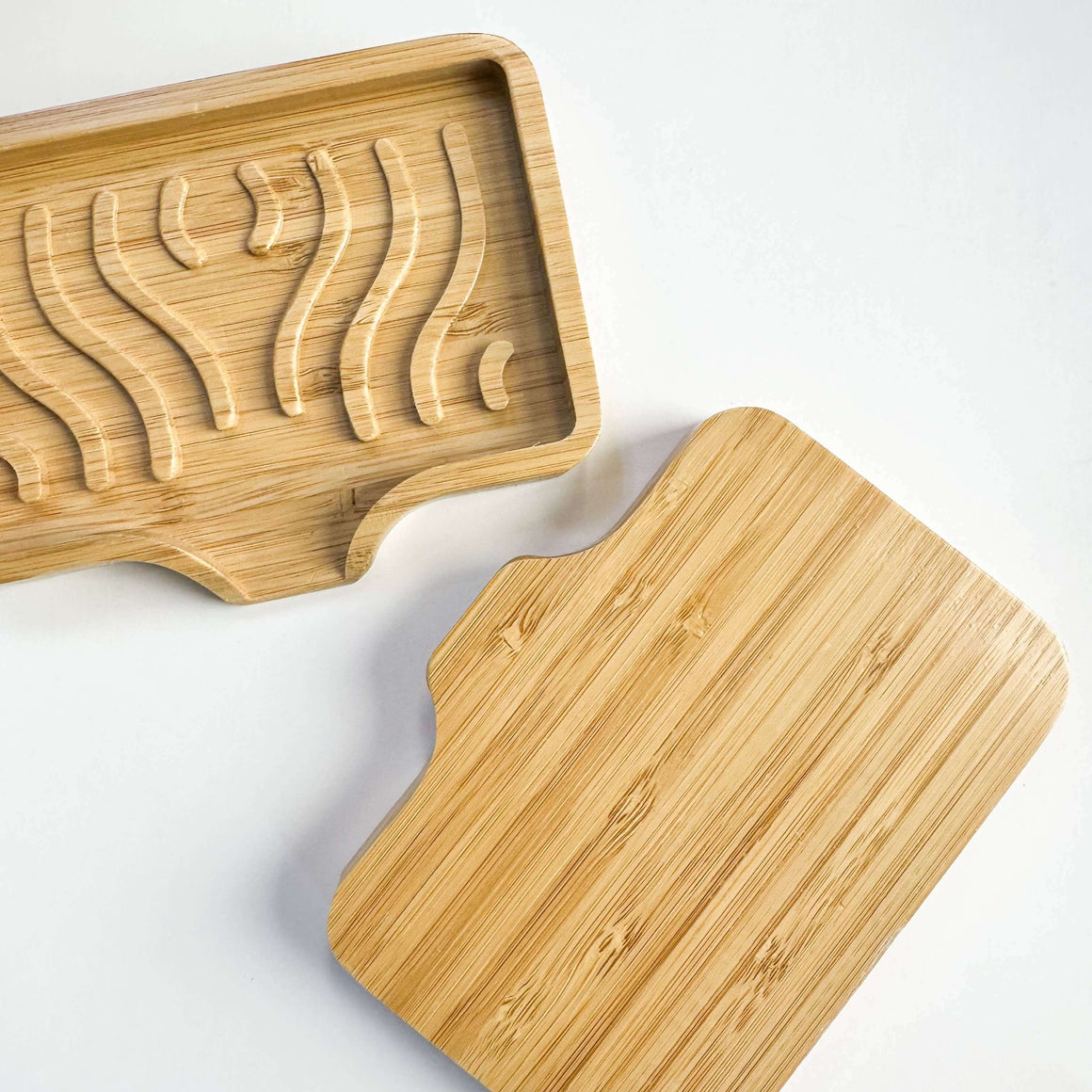Two wooden cutting boards with embossed designs on a white background