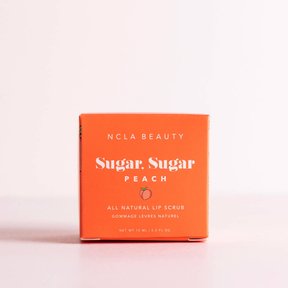 NCLA Beauty Sugar Sugar Peach lip scrub packaging on a light pink background