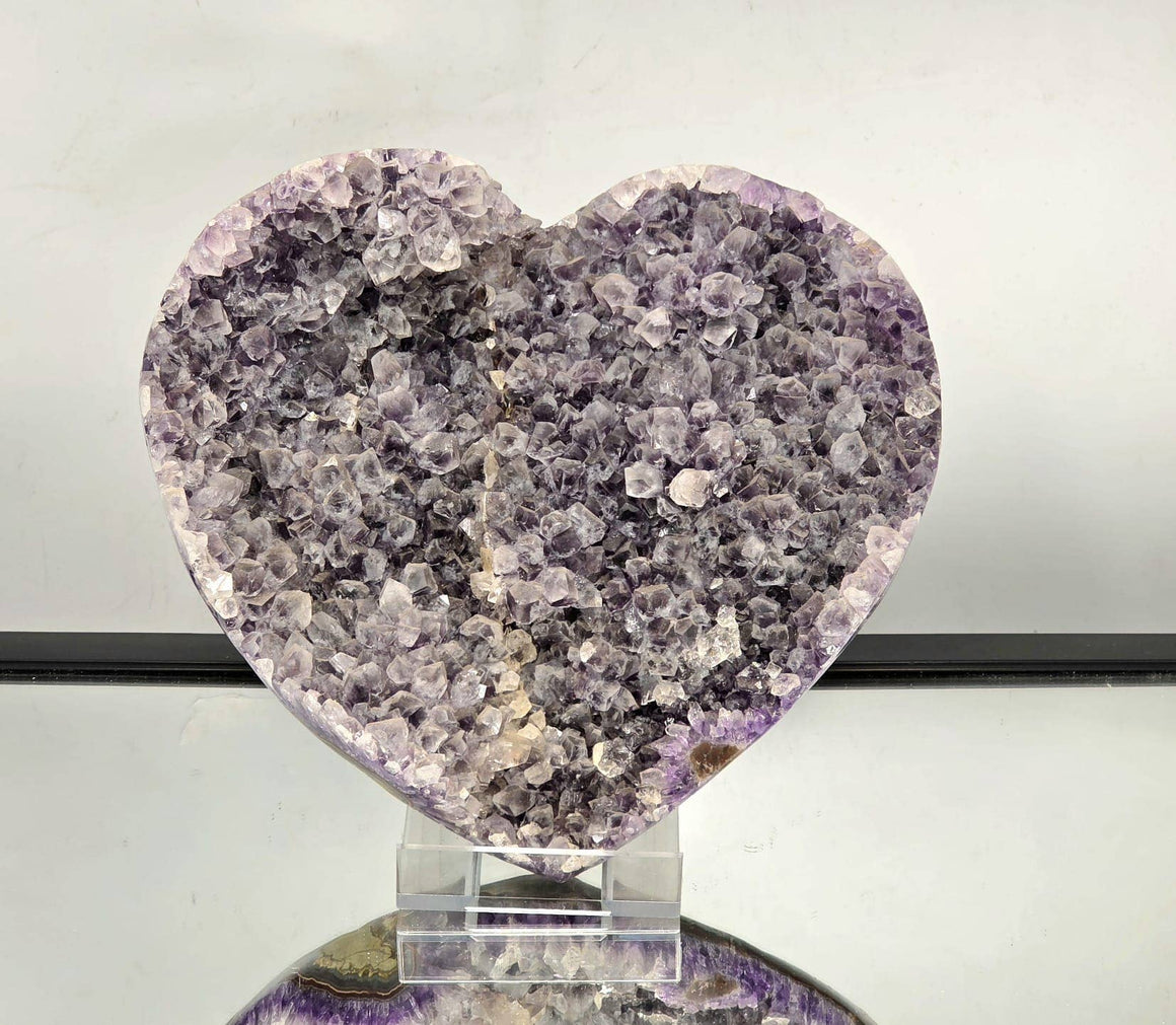 Heart-shaped crystal on a stand with a light gray background