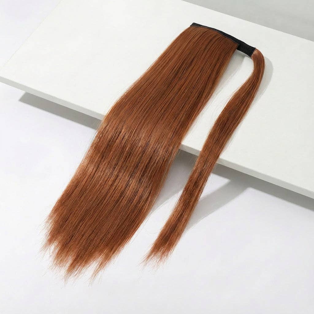 auburn silky straight ponytail extension on a table, showcasing its long, sleek design perfect for instant hairstyle upgrades.