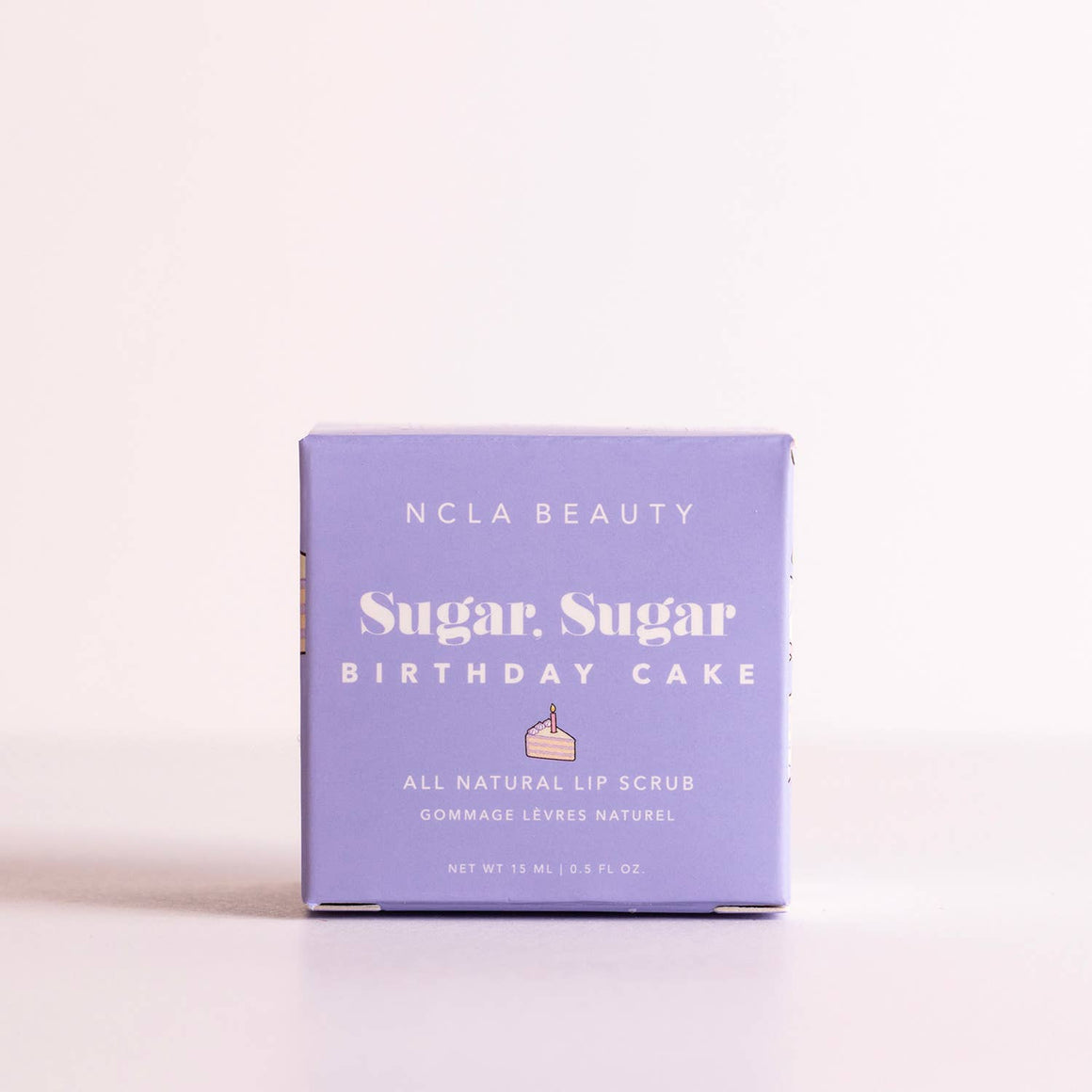 NCLA Beauty Sugar Sugar Birthday Cake lip scrub packaging on a light pink background