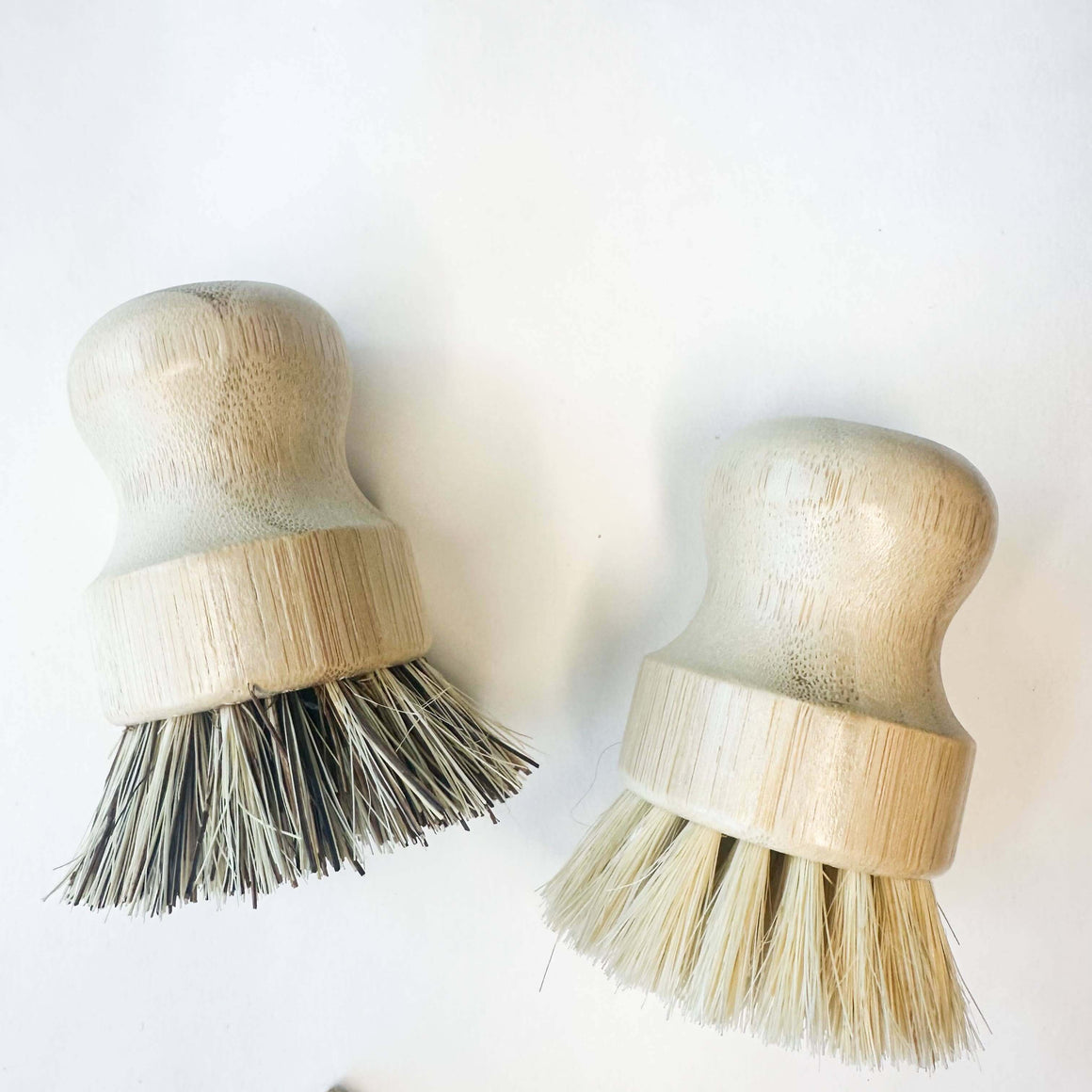 Two wooden brushes with bristle heads on a white background