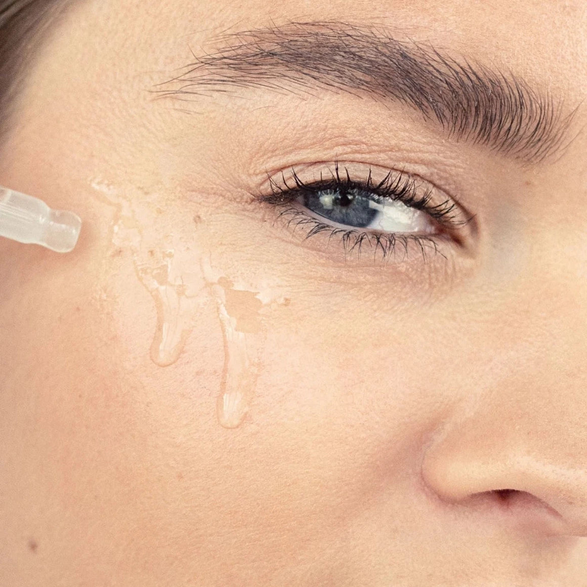 Close-up of a woman's eye with a droplet of liquid on her face