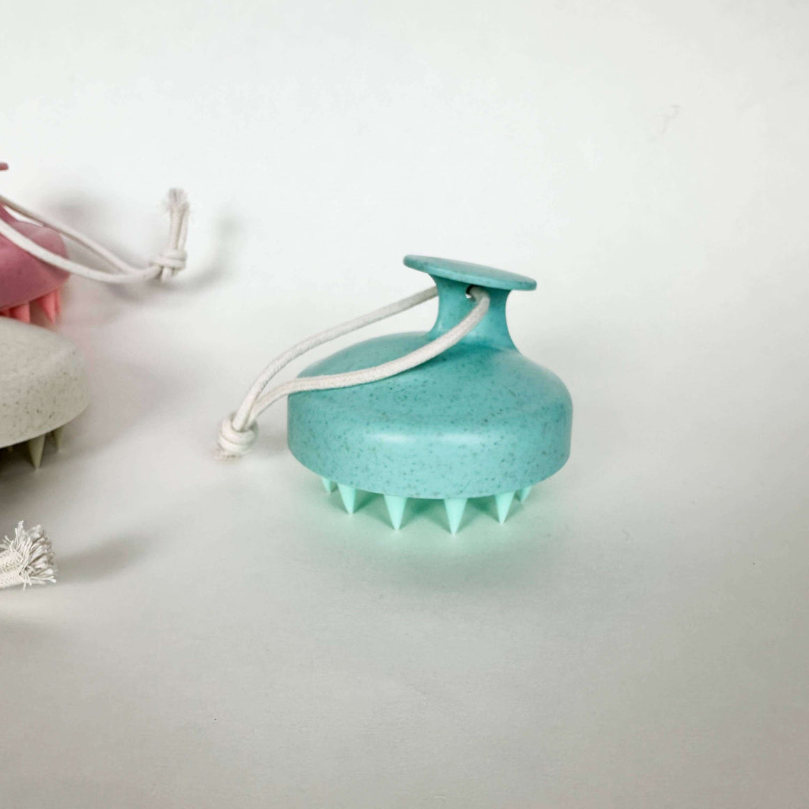 Turquoise scalp massager on a white background