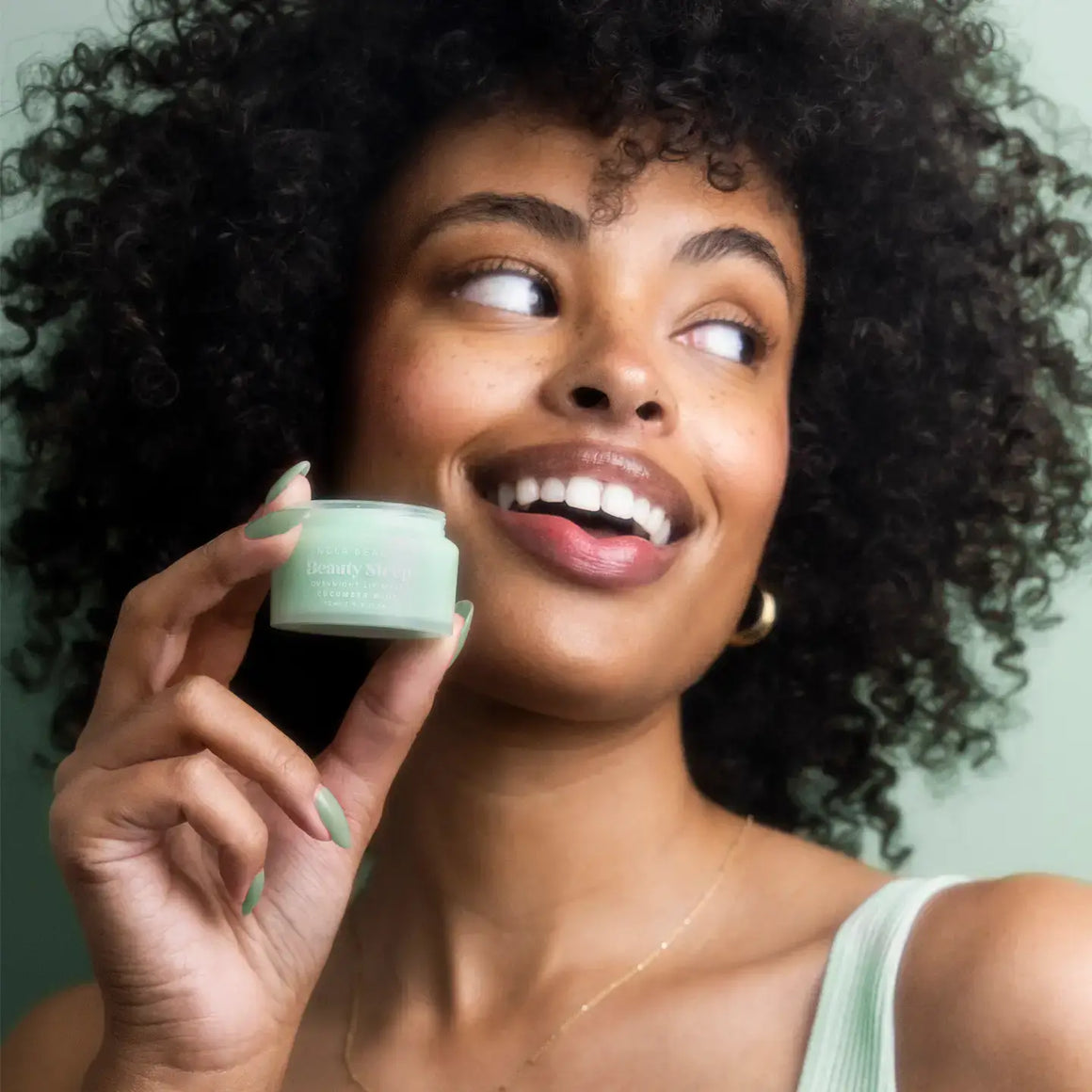 Beauty Sleep Overnight Lip Mask – Cucumber Mint held by a smiling woman, showcasing soft, hydrated lips.