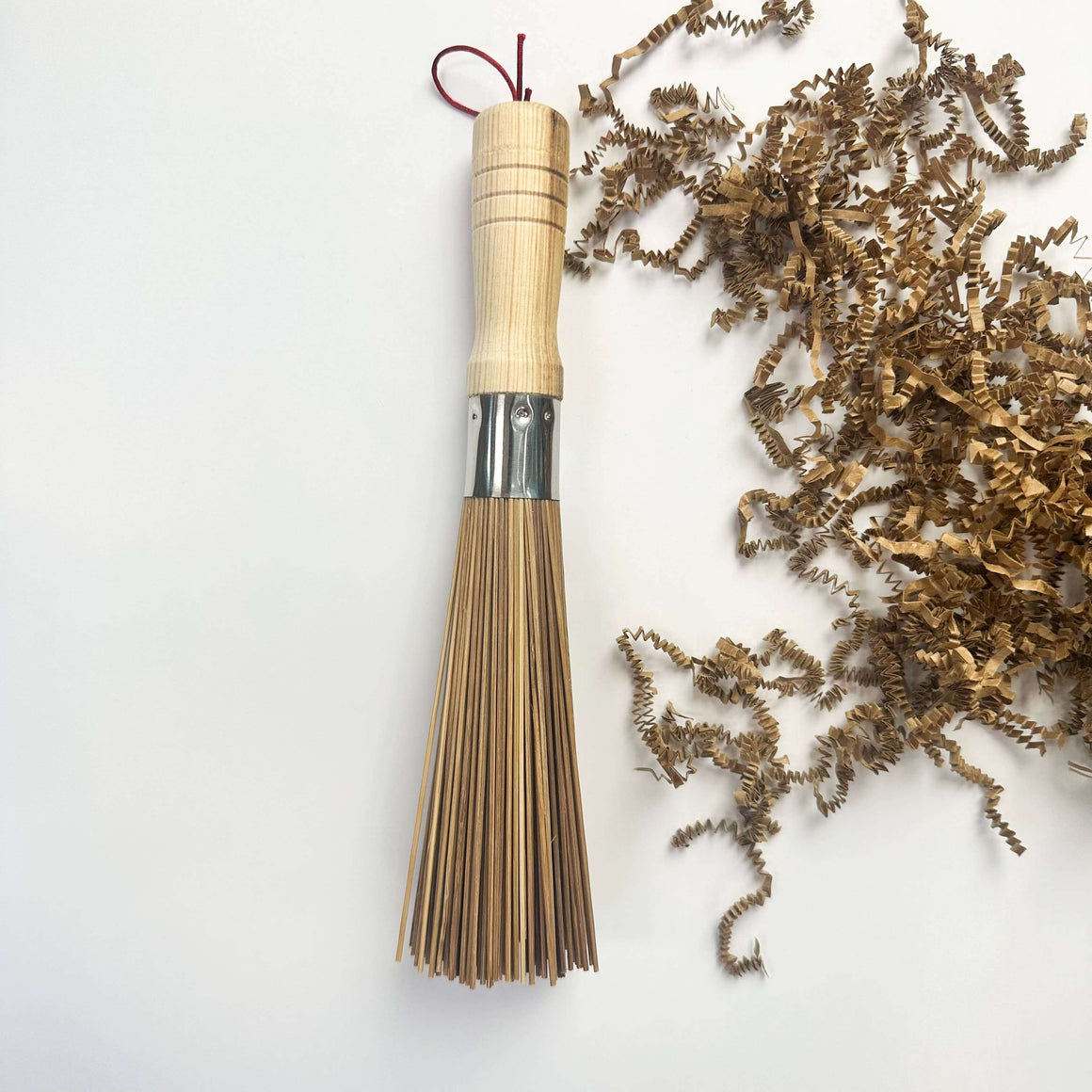 Bamboo whisk with a wooden handle on a white background