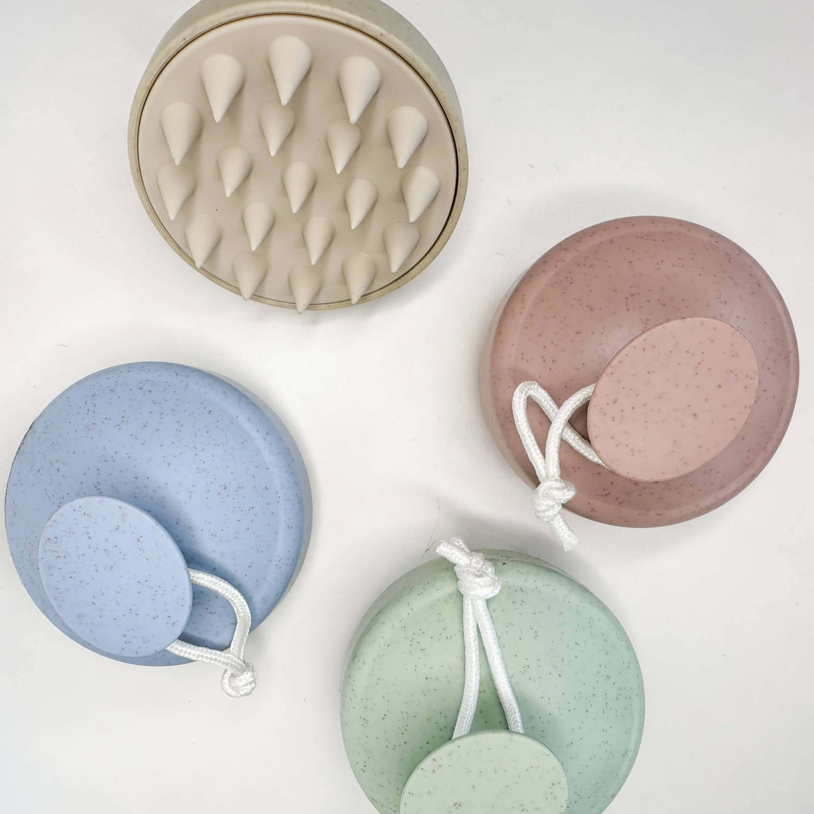 Set of five silicone face scrubs in different colors on a white background