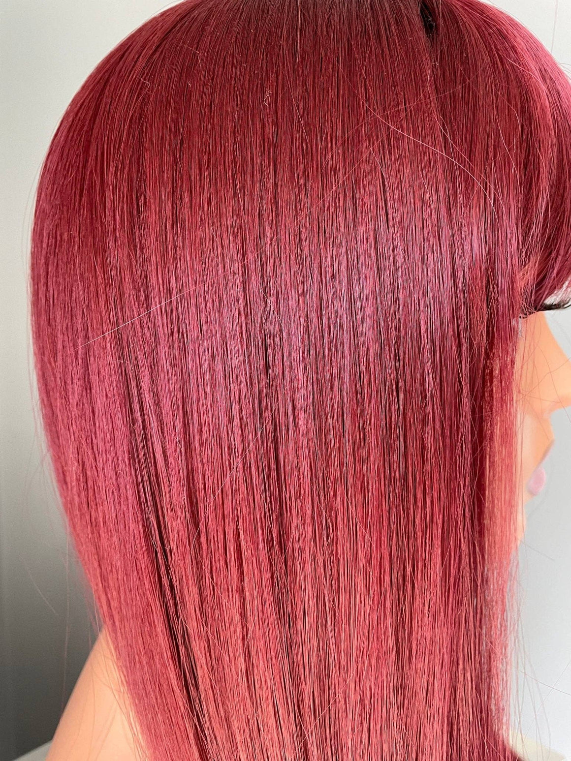 Close-up of the Raven long wine red silky straight wig with bangs, showcasing its sleek, glossy strands.