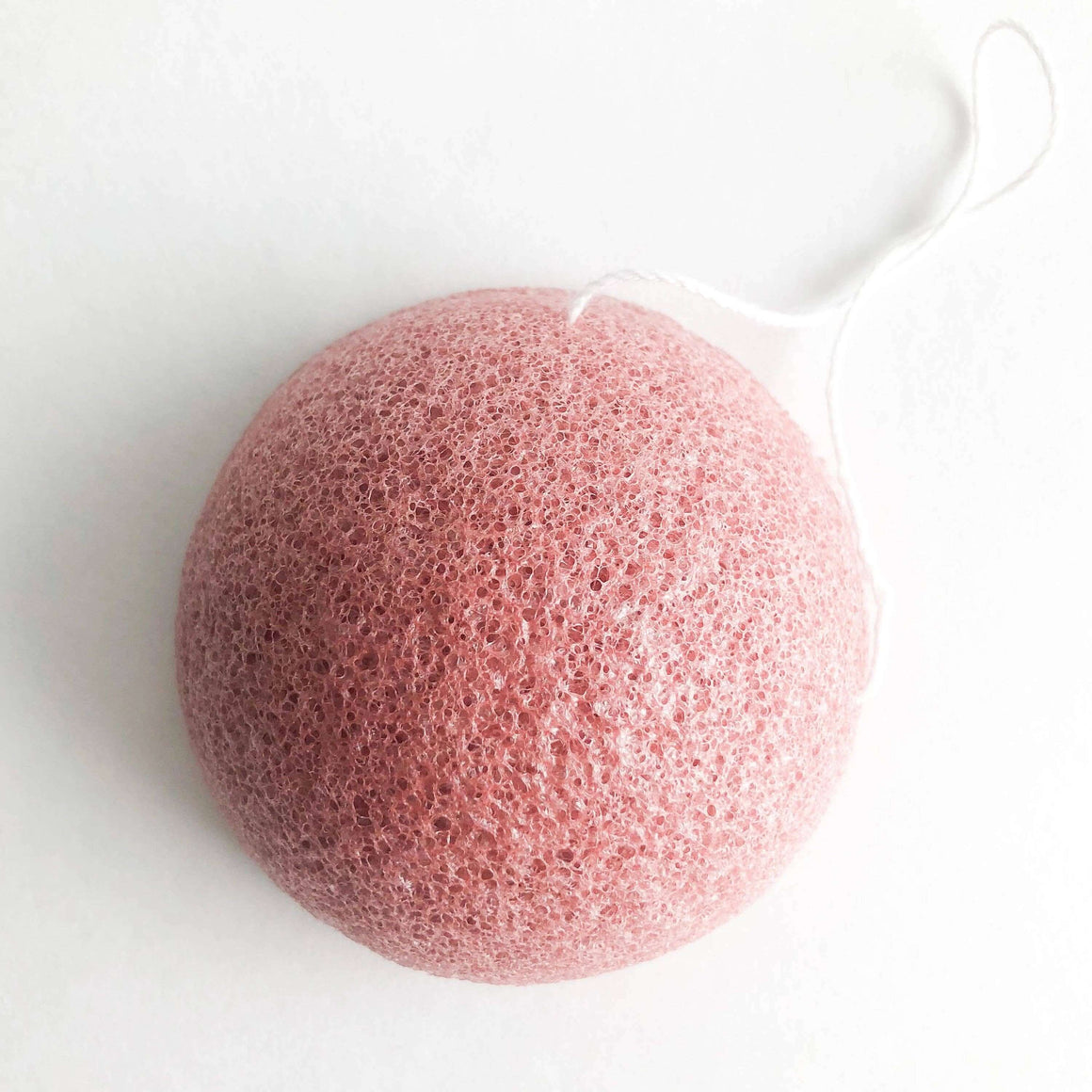 Pink konjac sponge on a white background