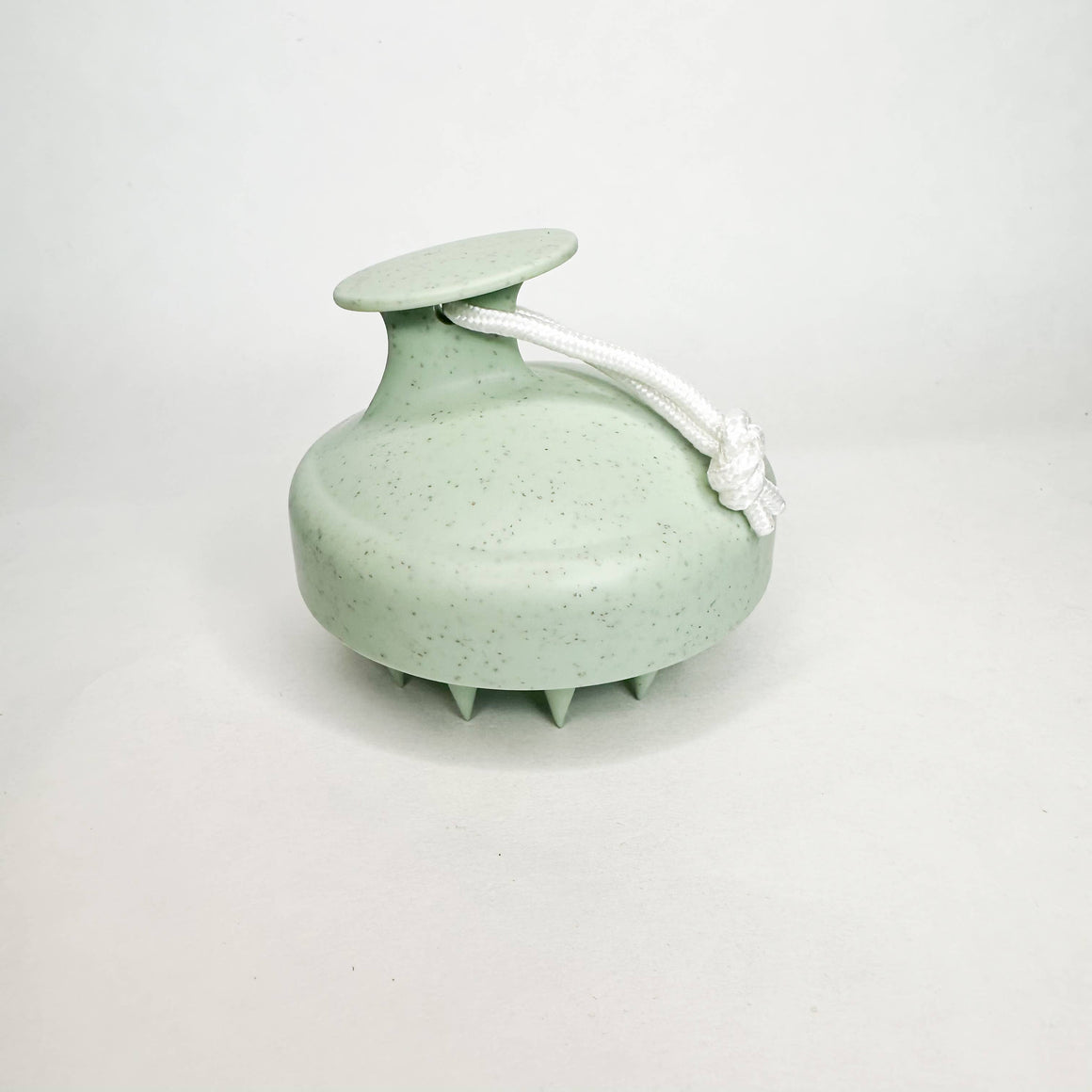 Green scalp massager on a white background